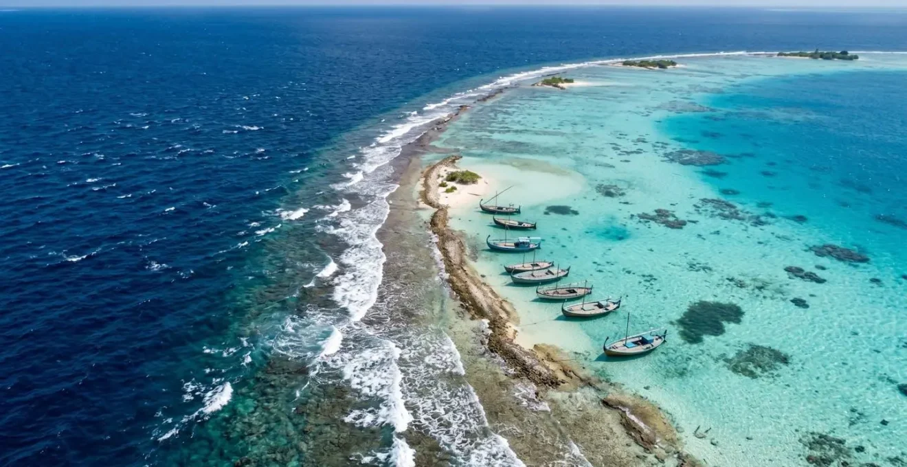 Vue aérienne d'un atoll des Maldives montrant le contraste entre côté abrité et exposé