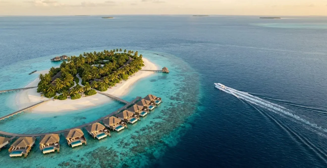 Vue aérienne d'un resort de l'atoll de Malé Nord avec son lagon turquoise et ses villas sur pilotis