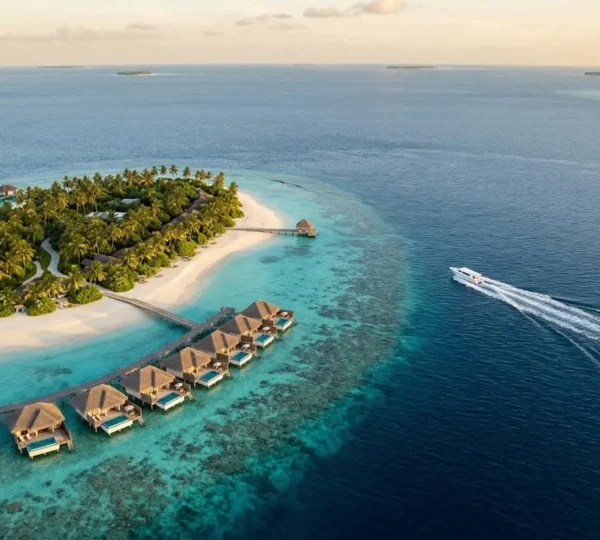 Vue aérienne d'un resort de l'atoll de Malé Nord avec son lagon turquoise et ses villas sur pilotis