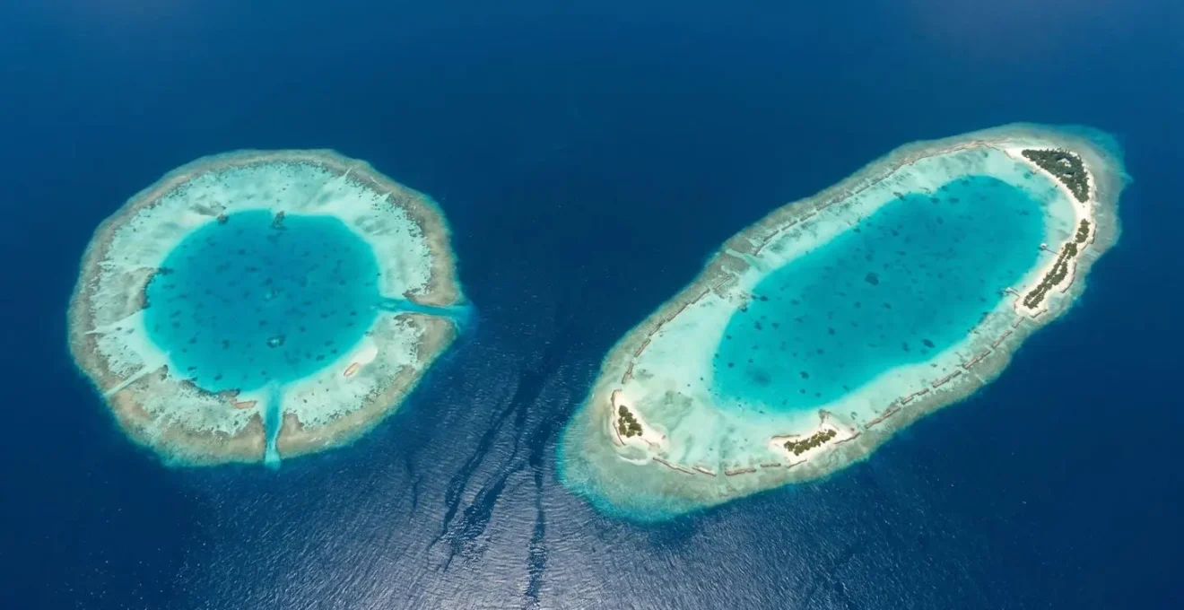 Vue aérienne comparative d'un atoll rond et d'un atoll étiré aux Maldives