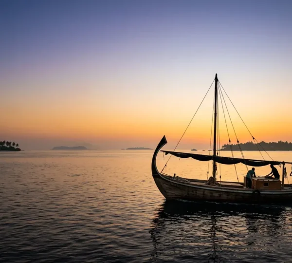 Dhoni traditionnel maldivien naviguant au coucher du soleil entre les atolls