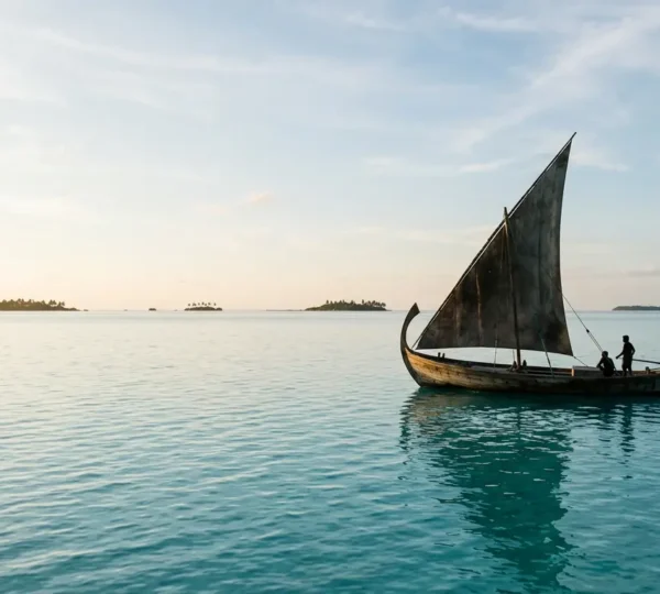 Bateau traditionnel dhoni naviguant sur les eaux turquoise cristallines des Maldives