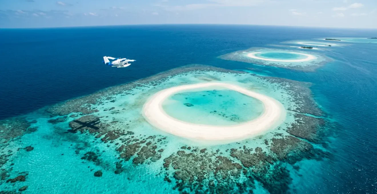 Vue aérienne spectaculaire des lagons turquoise et atolls coralliens des Maldives avec un hydravion survolant les îles