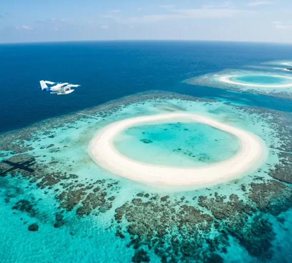 Vue aérienne spectaculaire des lagons turquoise et atolls coralliens des Maldives avec un hydravion survolant les îles