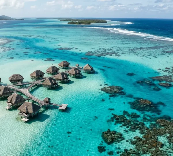 Vue aérienne d'un lagon turquoise montrant les variations de profondeur à travers différentes nuances de bleu