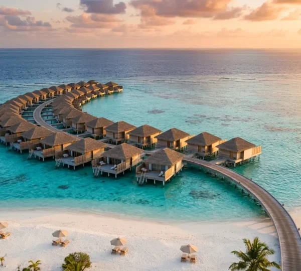 Vue panoramique d'un resort 4 étoiles aux Maldives avec villas sur pilotis et plage de sable blanc