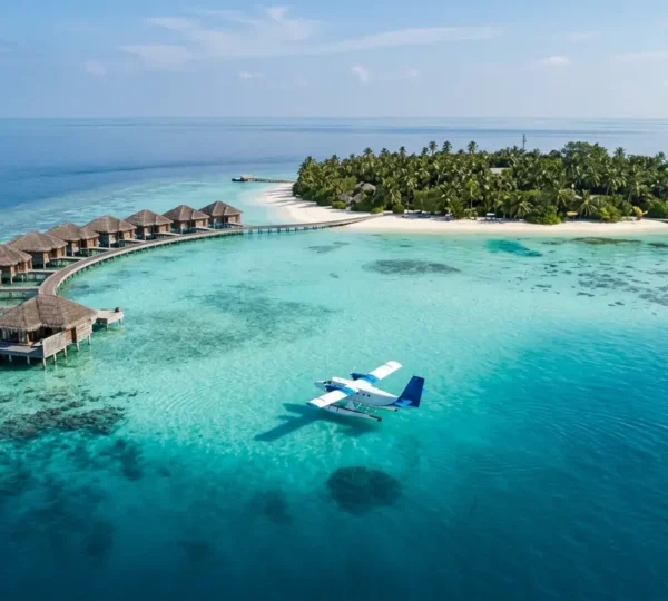 Vue aérienne d'une île des Maldives avec bungalows sur pilotis et lagon turquoise