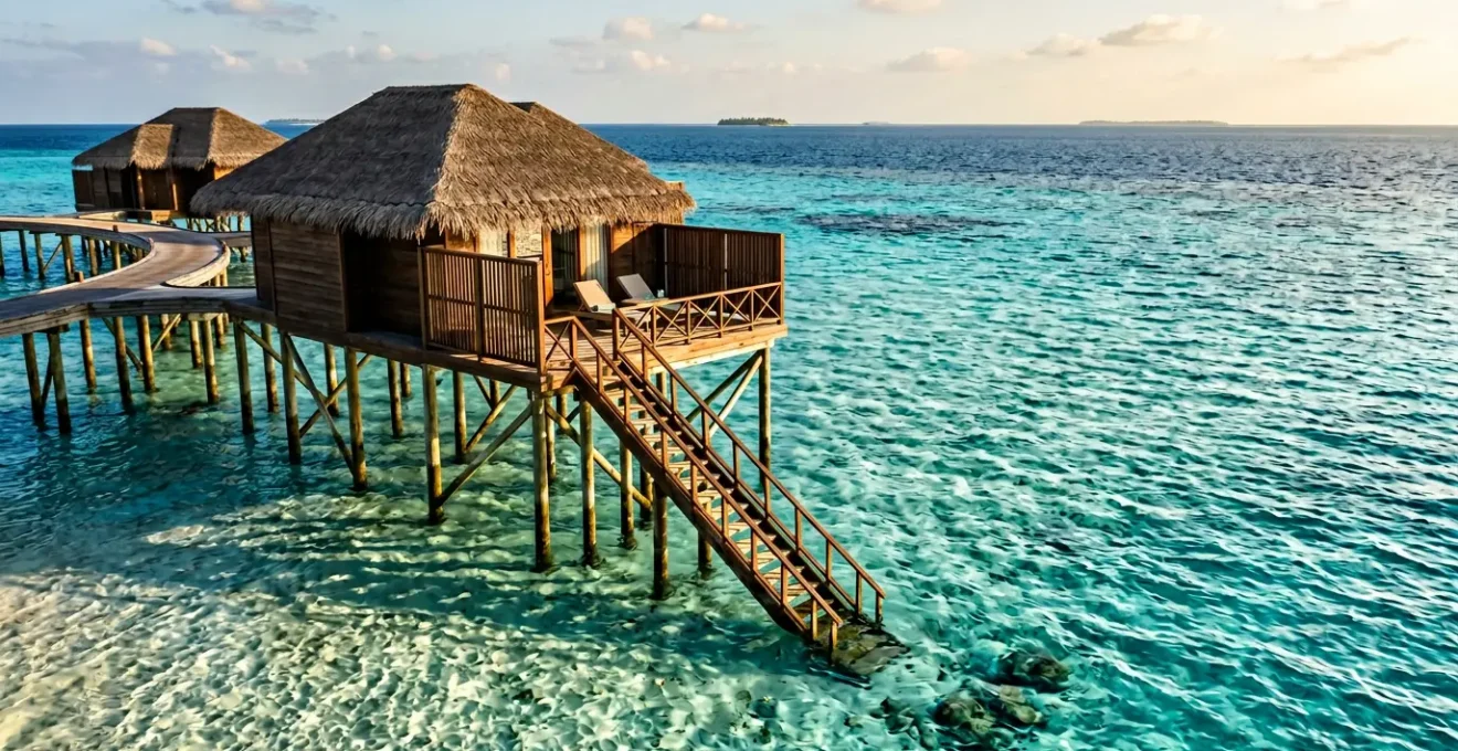 Vue aérienne d'une villa sur pilotis avec accès direct au lagon turquoise et escalier immergé