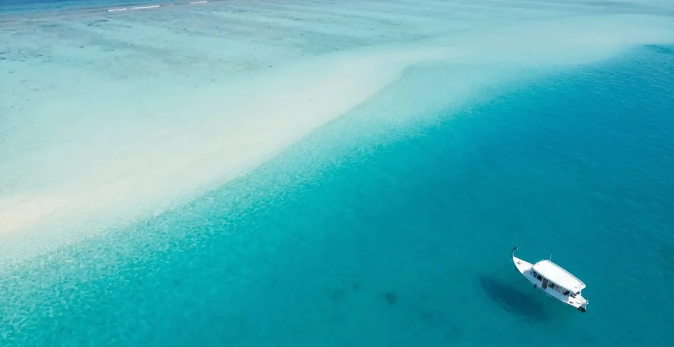 Vue aérienne minimaliste d'un lagon maldivien avec zone de baptême sur fond de sable blanc