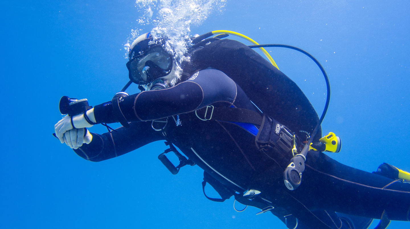 Vue sous-marine depuis le fond montrant un rideau massif de bulles d'air argentées s'échappant et montant vers la surface lumineuse dans un dégradé d'eau bleue profonde allant du noir au bleu clair